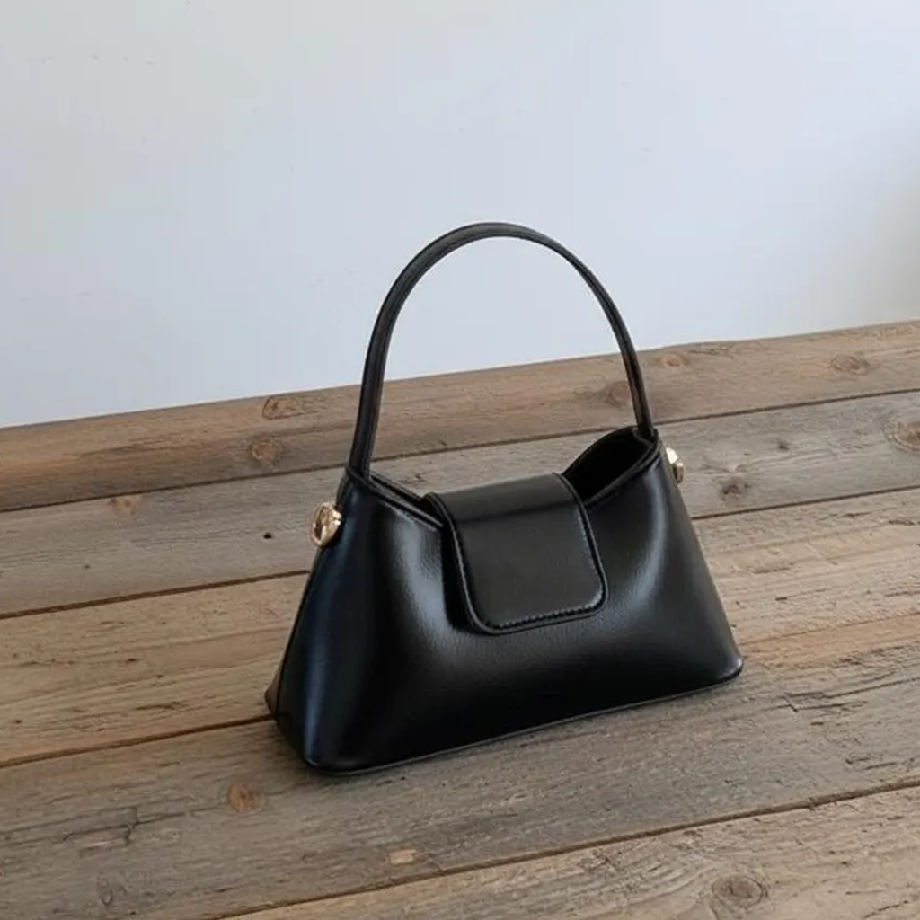 Solid Black Tapered Trapezoid Mini Satchel With Curved Slim Top Handle, Metallic Side Stud Accents And Rectangular Magnetic Front Flap Panel