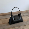 Solid Black Tapered Trapezoid Mini Satchel With Curved Slim Top Handle, Metallic Side Stud Accents And Rectangular Magnetic Front Flap Panel