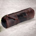 Weathered Dark Brown Cylindrical Stationery Pouch With Segmented Stitched Panels, Full Length Top Zipper And Metal Stud Reinforced Fabric Pull Tab